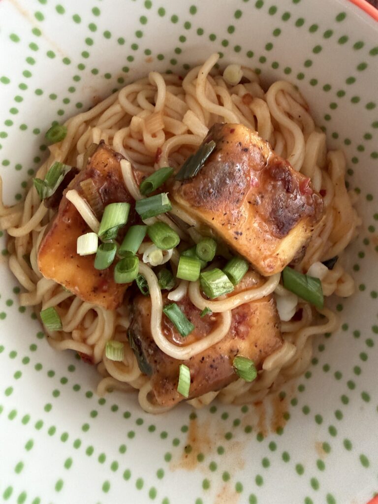 bowl of noodles with paneer topping